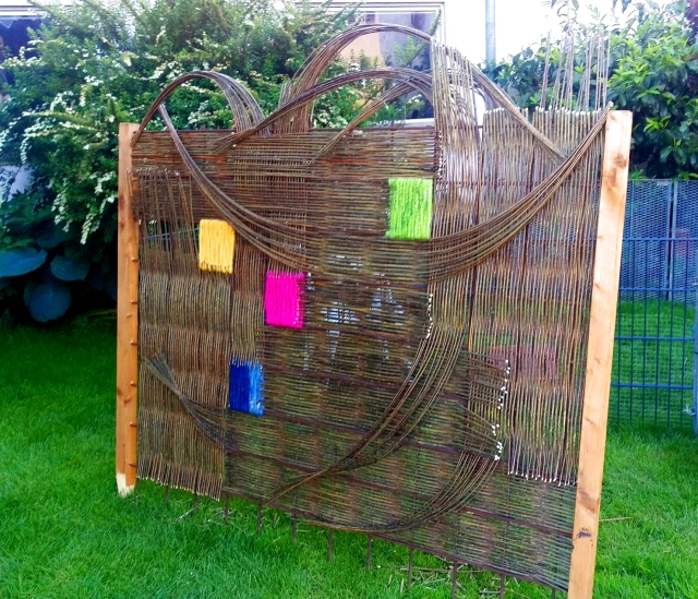 künstlerische Weidenflechtung, mit mehreren Bögen und Schwüngen, mit 4 bunten Stellen